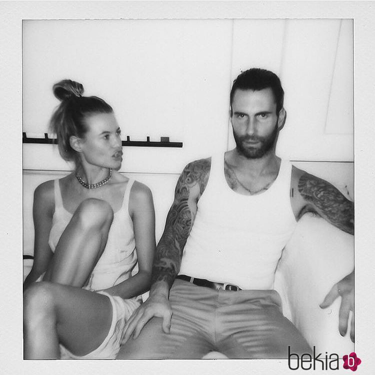 Adam Levine y Behati Prinsloo sentados por su tercer aniversario