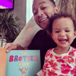 John Legend junto a su hija Luna leyendo un libro