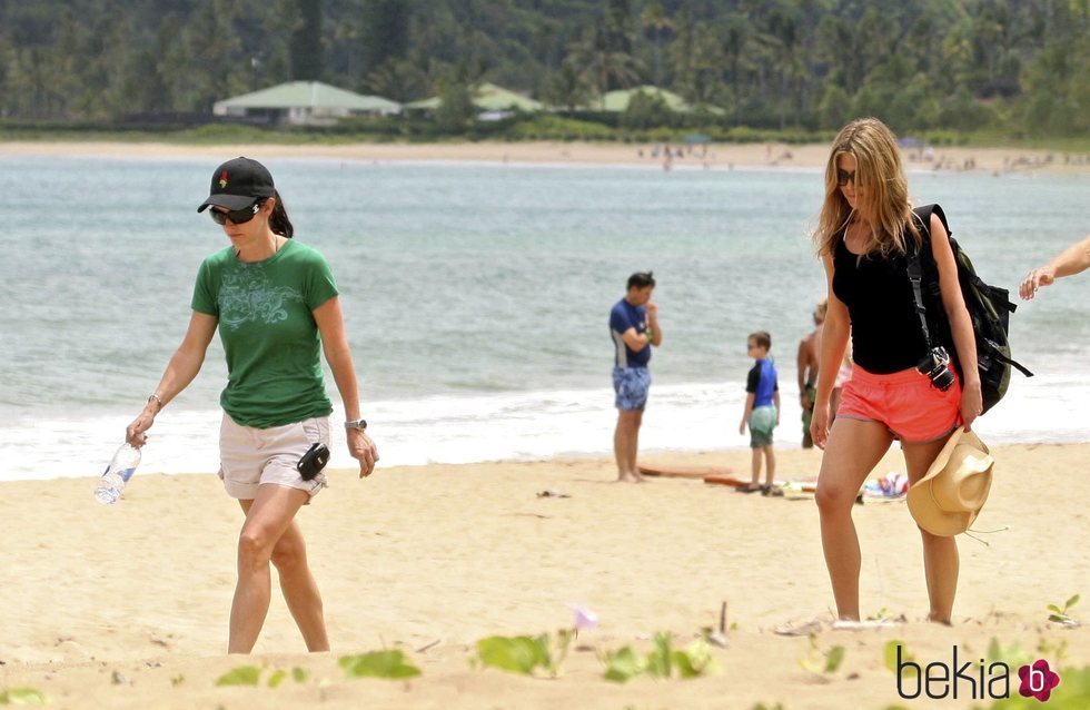 Courteney Cox y Jennifer Aniston paseando por una playa de Hawái