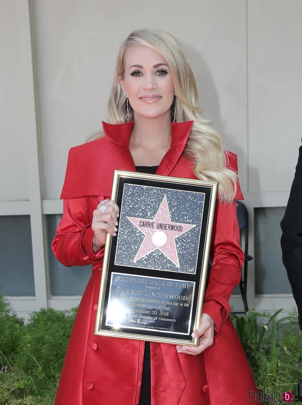 Carrie Underwood posando con su estrella en el Paseo de la Fama de Hollywood