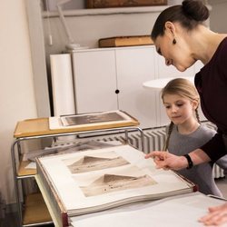 Victoria de Suecia enseña a su hija Estela unas fotos familiares antiguas en la Biblioteca Bernadotte