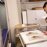 Victoria de Suecia enseña a su hija Estela unas fotos familiares antiguas en la Biblioteca Bernadotte