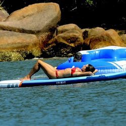 Alessandra Ambrosio tomando el sol en una tabla de surf