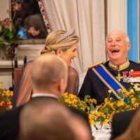 Máxima de Holanda y Harald de Noruega riendo en la cena de gala por la Visita de Estado de los Reyes de Holanda a Noruega