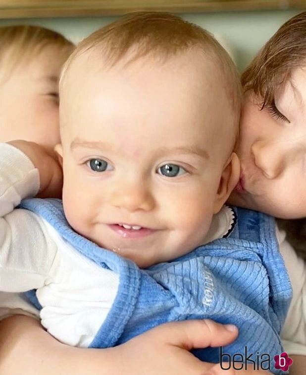 Alejandro y Gabriel de Suecia dando un beso a Julian de Suecia
