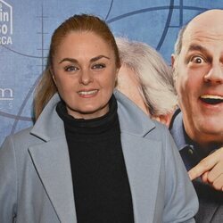 Carmen Morales posa con un abrigo azul en frente al cartel promocional del Teatro Reina Victoria