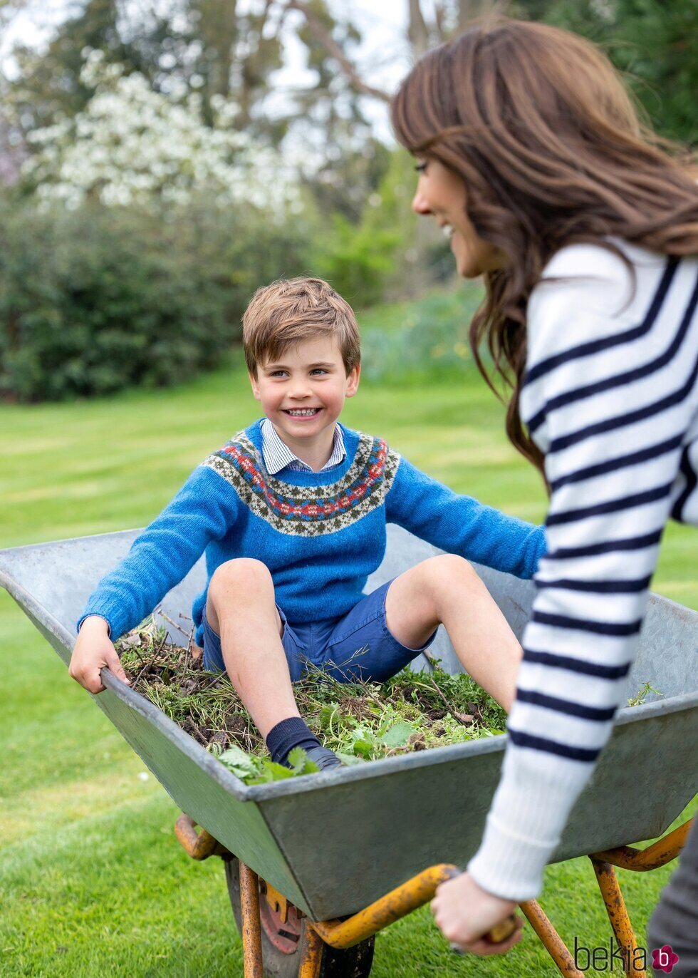Kate Middleton llevando en una carretilla al Príncipe Louis en el jardín