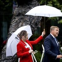 Guillermo Alejandro de Holanda pronuncia su discurso sobre la esclavitud mientras le tapan con un paraguas