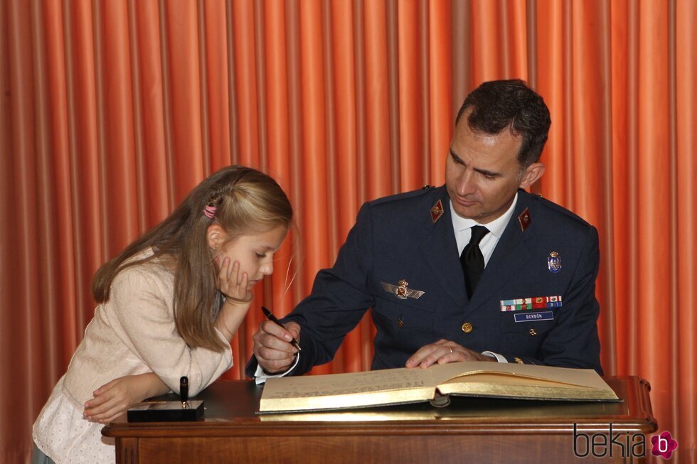 La Princesa Leonor mirando cómo firma el Rey Felipe VI en la Academia General del Aire de San Javier en una foto inédita por su 18 cumpleaños