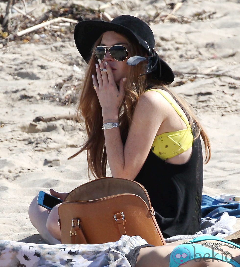 Lindsay Lohan sentada en su toalla en las playas de Malibú