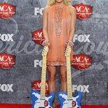 Carrie Underwood muy sonriente con sus premios en los American Country Awards 2012