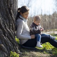 Victoria de Suecia y la Princesa Estela sentadas junto a un árbol