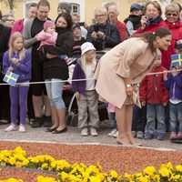 Victoria de Suecia saluda a unos niños en la inauguración de una exposición sobre la Princesa Estela