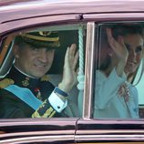 El Rey Felipe VI y la Reina Letizia saludan durante el recorrido hasta el Congreso de los Diputados