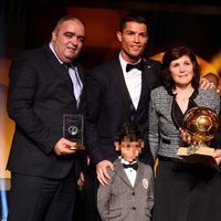 Cristiano Ronaldo posando con el Balón de Oro 2014 junto a su familia