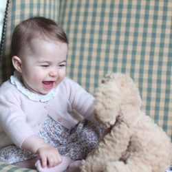 La Princesa Carlota de Cambrigde muy sonriente jugando con un oso de peluche